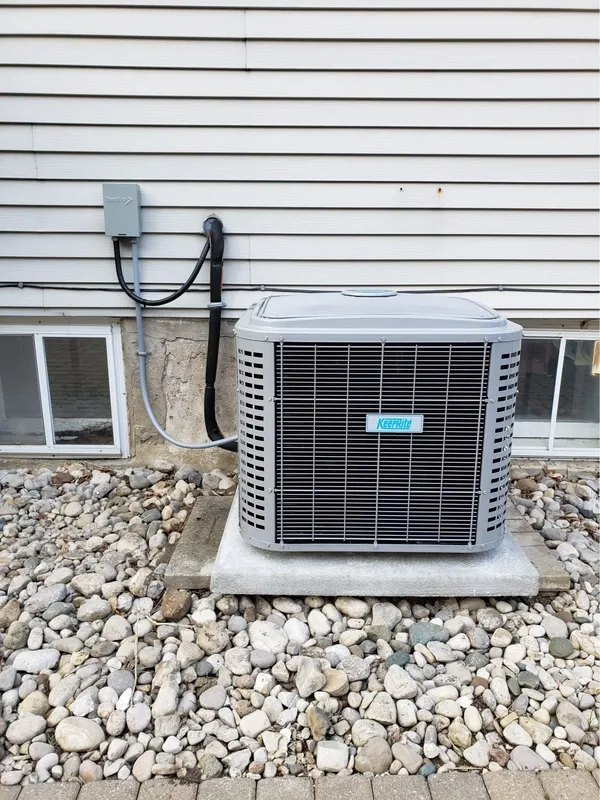 Central air conditioning unit installed beside a residential home