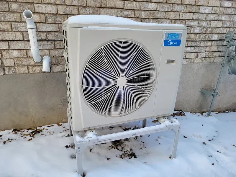 Cold-climate air-source heat pump mounted outside a Kitchener-Waterloo home